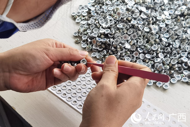 周小鳳組裝耳機(jī)零件。人民網(wǎng) 覃心攝