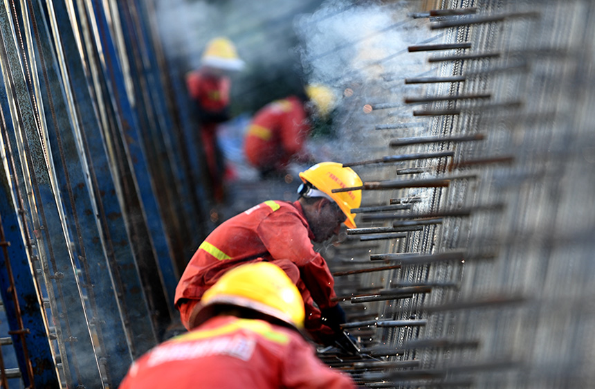 工人在捆扎鋼筋籠。