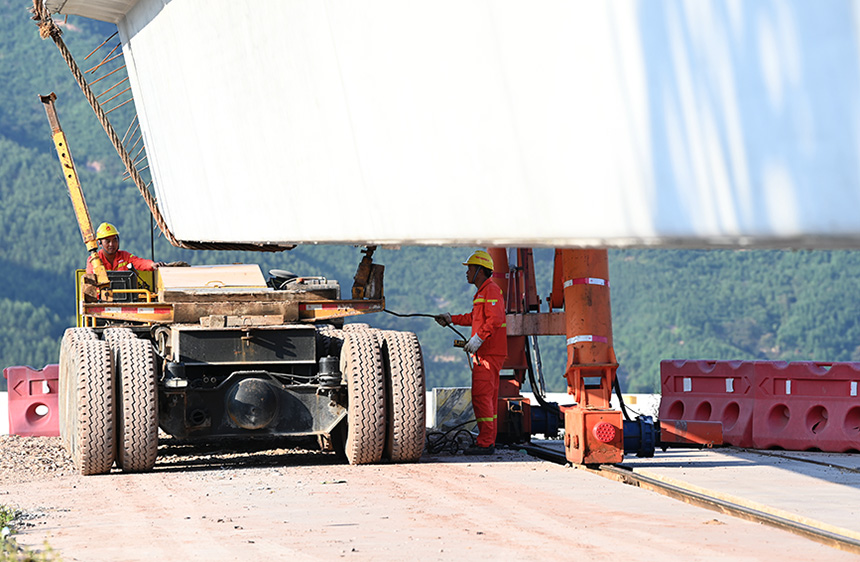 工人在吊裝預(yù)制箱梁。