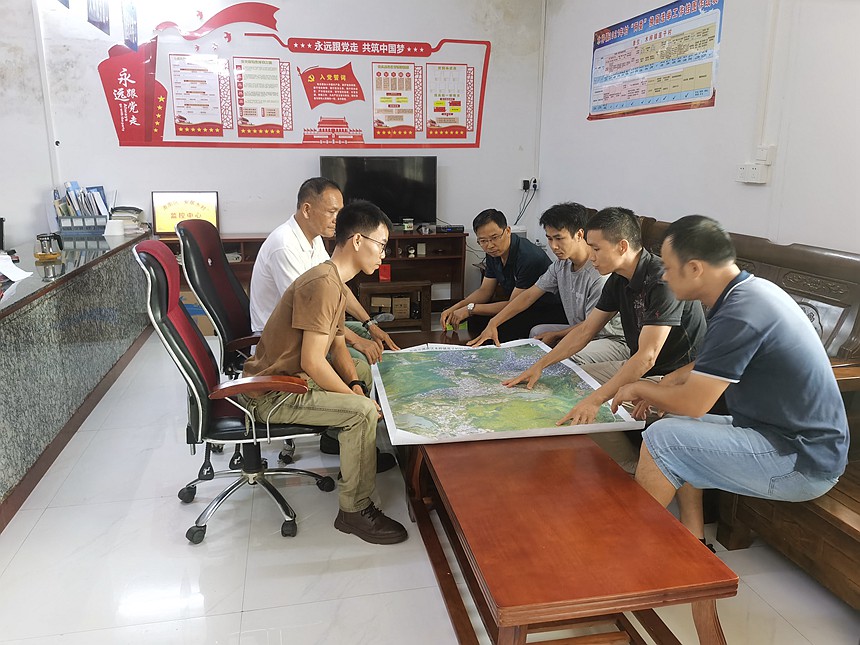 圖為第一書記覃先展（右二）、工作隊員農(nóng)祖慶（右三）與村委干部謀劃鄉(xiāng)村產(chǎn)業(yè)發(fā)展