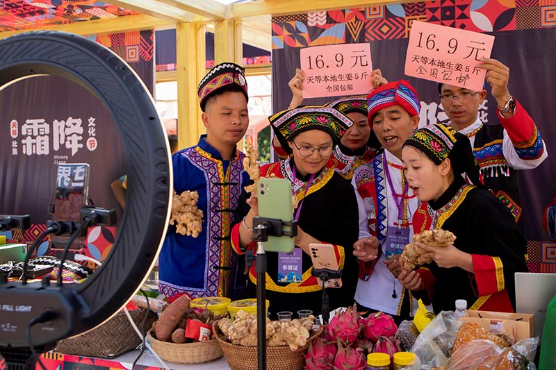 身著壯族服飾的主播正在為天等農(nóng)特產(chǎn)品直播帶貨。黃麗華攝