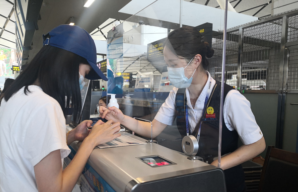 南航工作人員協(xié)助旅客填寫(xiě)目的地防疫信息。黃曉陽(yáng)攝