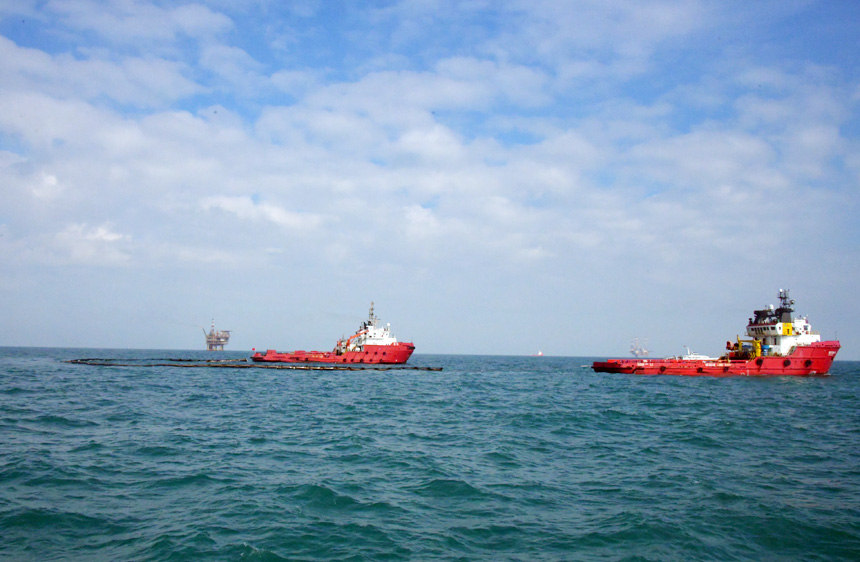 拖輪進行溢油圍控回收作業(yè)。