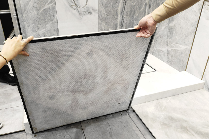 覃祖榮展示地磚的裝配方式。覃小倩攝