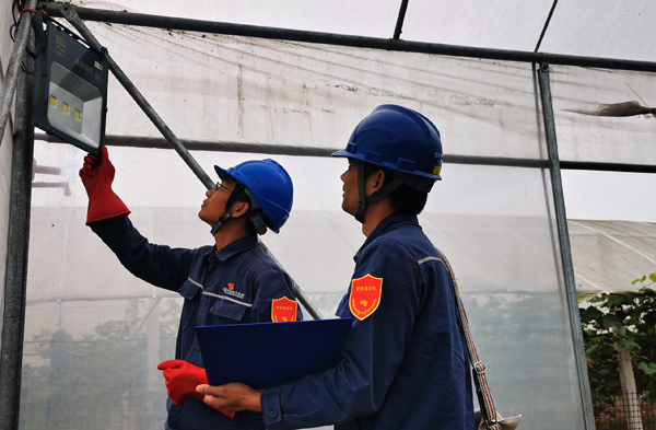 服務(wù)隊(duì)在走訪中主動(dòng)幫助農(nóng)莊檢測(cè)用電設(shè)備，確保果農(nóng)用電安全。謝忠敏攝