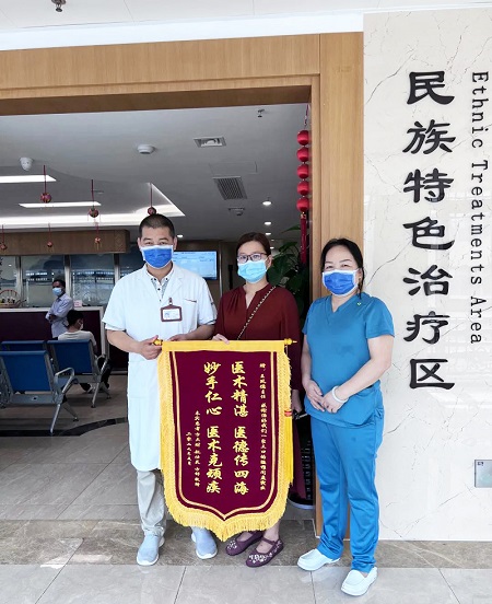 方女士給王鳳德送錦旗。廣西國際壯醫(yī)醫(yī)院供圖