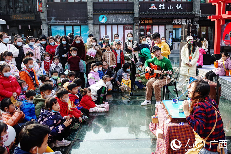 傍晚的東西巷內(nèi)，孩子們圍著演員聽故事。人民網(wǎng) 覃心攝