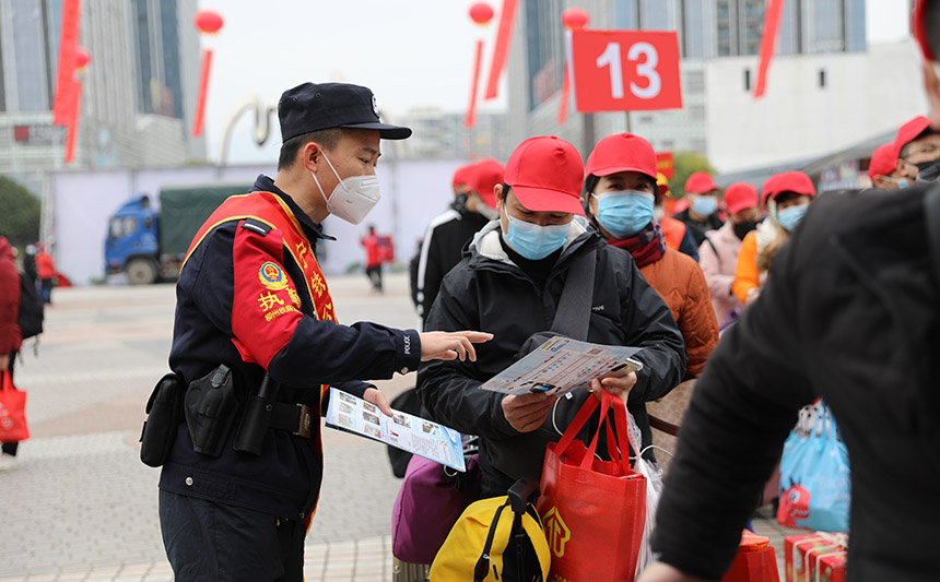 在進(jìn)站口發(fā)放出行安全注意事項(xiàng)宣傳單。胡玄德攝