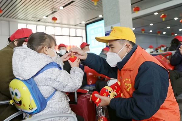 青年志愿者為務(wù)工專列旅客發(fā)放小燈籠等節(jié)日物品。陳雨雨攝