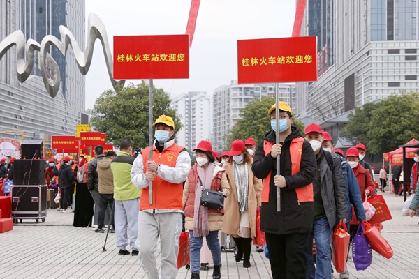 青年志愿者引導(dǎo)務(wù)工專列旅客有序進(jìn)站。陳雨雨攝