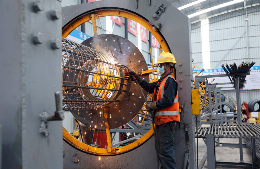 工人正在進(jìn)行鋼筋籠的焊接作業(yè)。