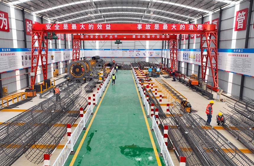 鋼筋加工廠內(nèi)，工人們正在有序開展作業(yè)。