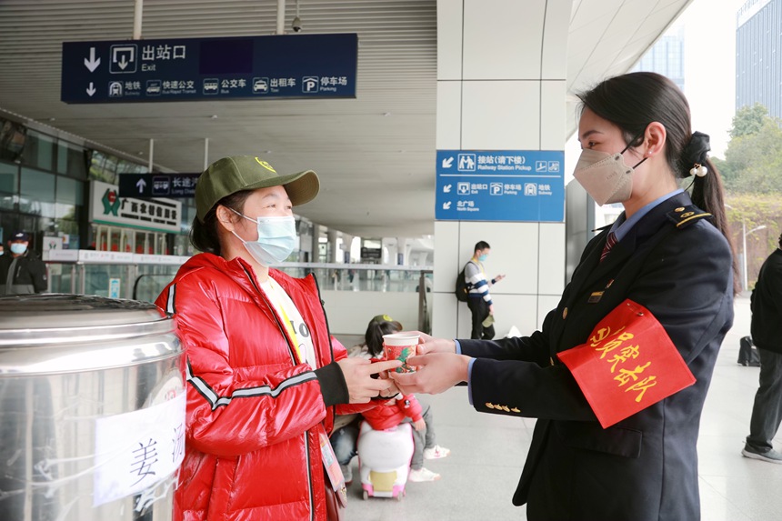 車站工作人員為即將搭乘務(wù)工專列的人員送上姜糖水。莉攝