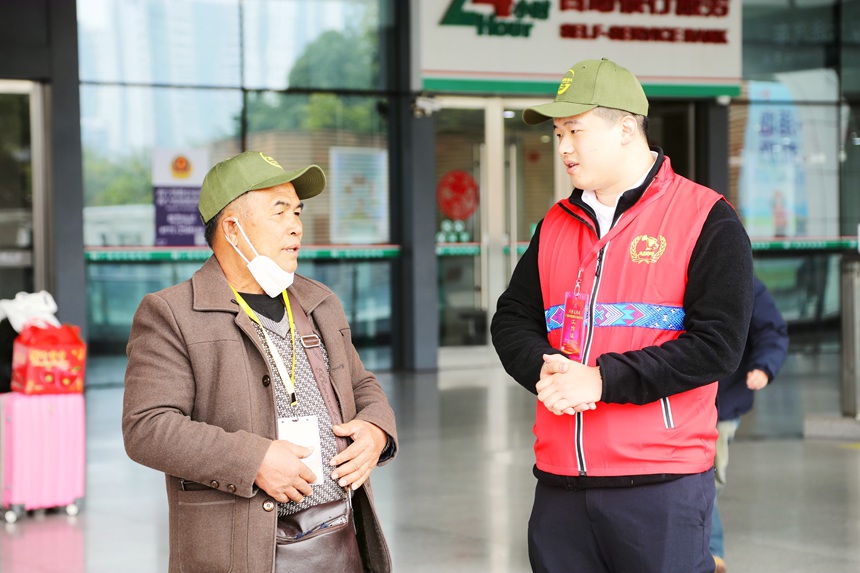 “八桂軍號”志愿服務隊員正在為退役軍人介紹務工專列開行時刻等信息。資音攝