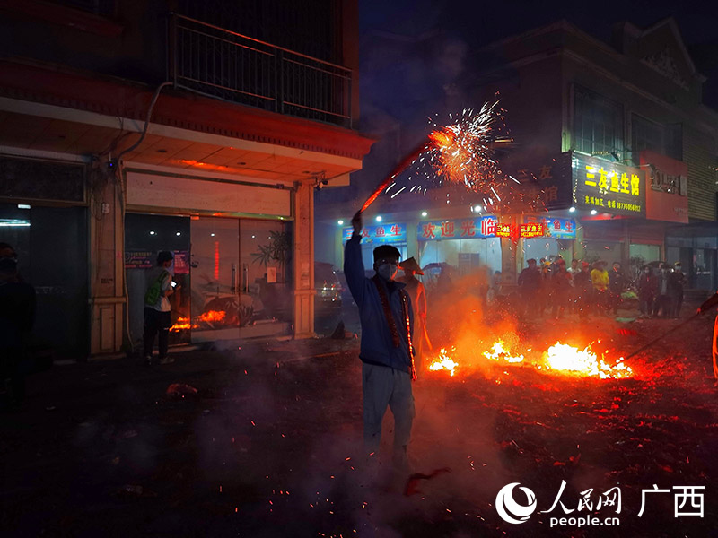 一名年輕人點燃鞭炮參與狂歡。人民網(wǎng) 付華周攝