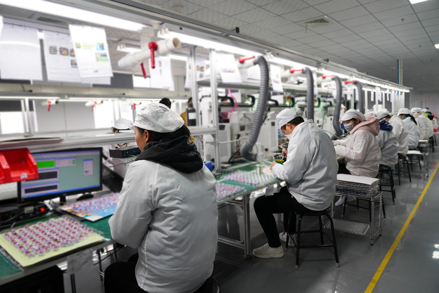 生產(chǎn)車間里工人對(duì)產(chǎn)品進(jìn)行加工。