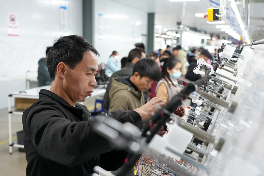 生產(chǎn)流水線上，工人加工產(chǎn)品。