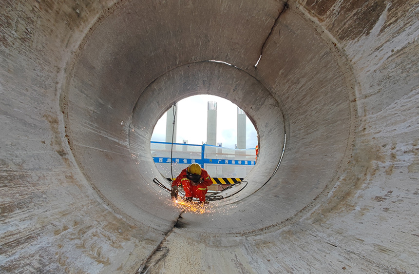 在上峒高速明江大橋臨時(shí)棧橋上，工人在切割拆除橋墩鐵管。