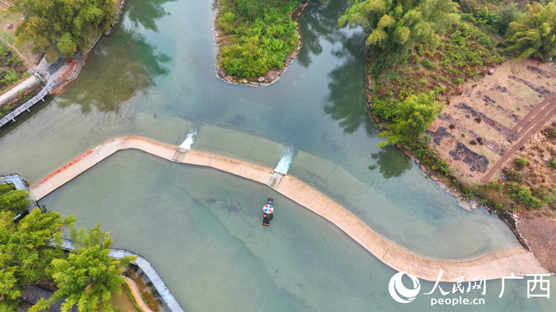 一艘竹筏準(zhǔn)備通過(guò)遇龍河水壩。人民網(wǎng) 付華周攝