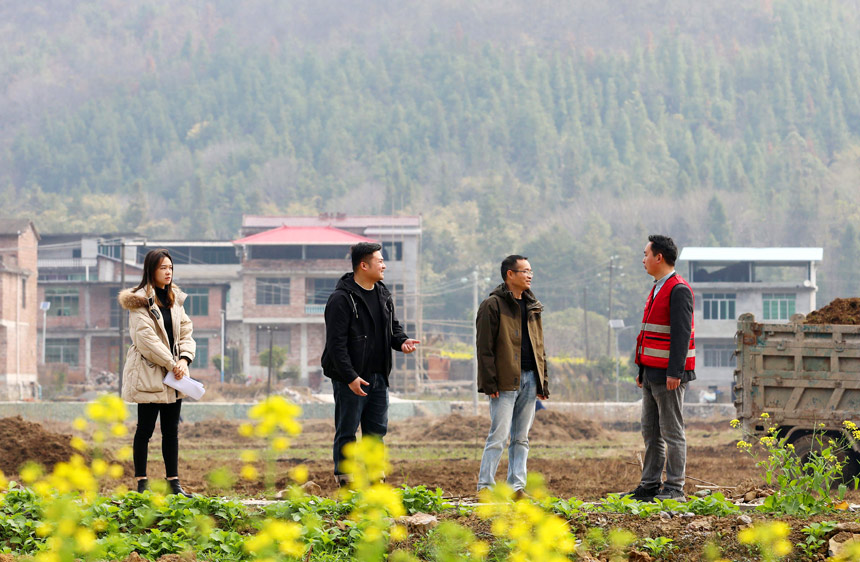 在融安縣橋板鄉(xiāng)古丹村田地里，融安縣技術(shù)人員正在指導(dǎo)撂荒田的復(fù)耕工作。