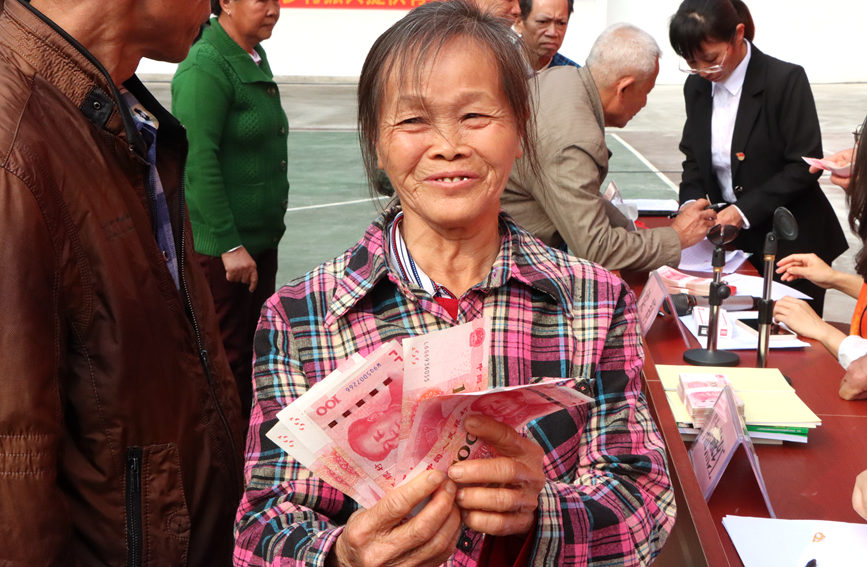 村民領(lǐng)到分紅臉上洋溢著幸福的笑容。李虹瑩攝
