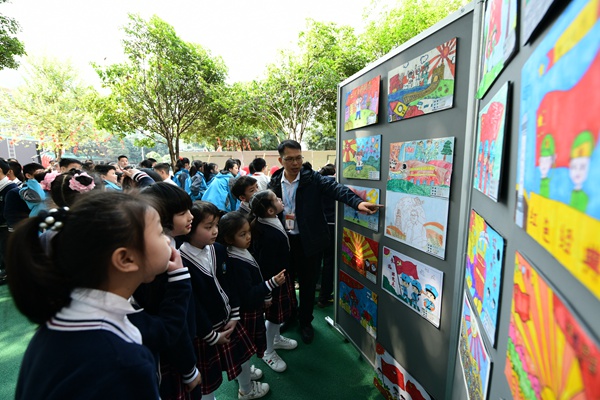 活動現(xiàn)場，同學們在認真聆聽老師講解紅色書畫作品。