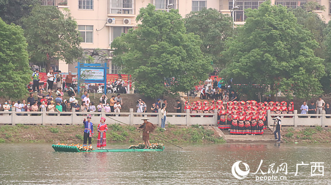 當(dāng)天的婚俗演繹中，以“歌仙引渡山歌亮”作為開場。穿城而過的明江河上傳來悠揚(yáng)清亮的山歌，兩岸分別有男女兩個(gè)山歌對唱陣營在對山歌，阿哥阿妹用歌傳情、用詞達(dá)意。人民網(wǎng)記者 彭遠(yuǎn)賀攝