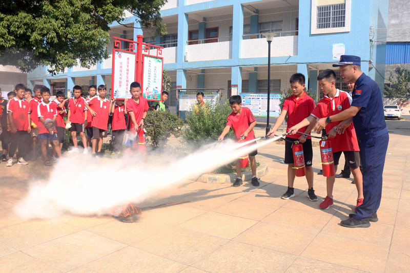 鐘山鎮(zhèn)第八小學(xué)的孩子們?cè)谶M(jìn)行滅火演練。廖超文攝