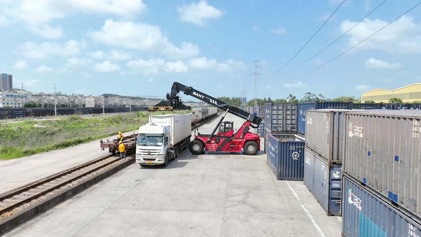 防城港車站貨場內(nèi),正面吊正在將冷藏箱吊運至火車上。陳磊攝