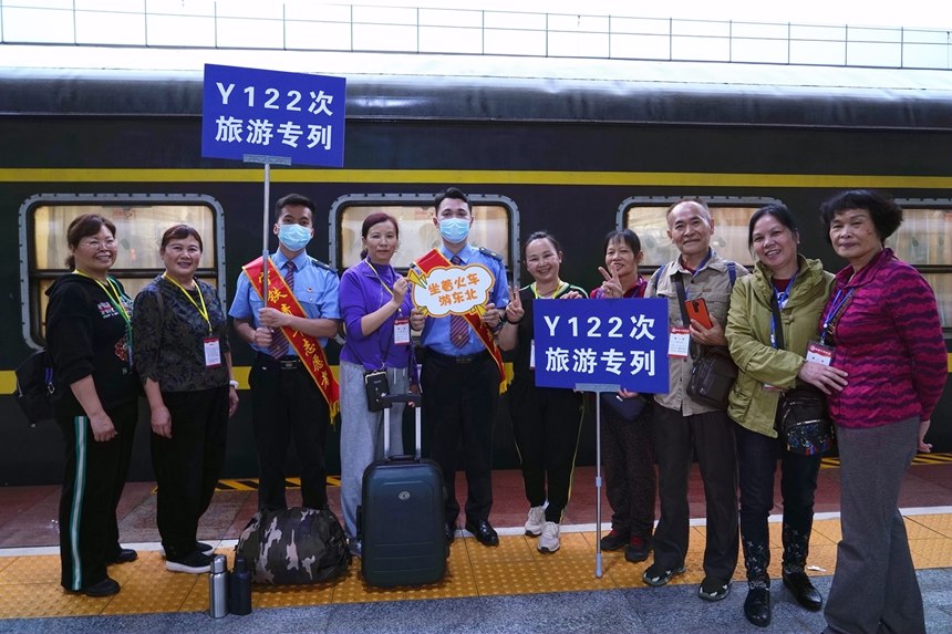 旅客在旅游專列前合影。梁競輝攝