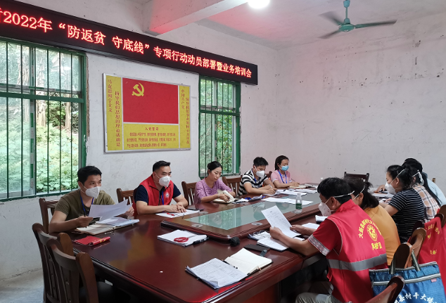 伍章余（左二）與念典村“兩委”班子開(kāi)會(huì)。許倩攝