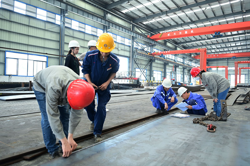 工人正在抽檢原料鋼板。黃蕊攝