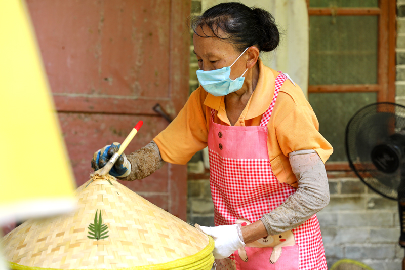 村民為竹編帽上漆
