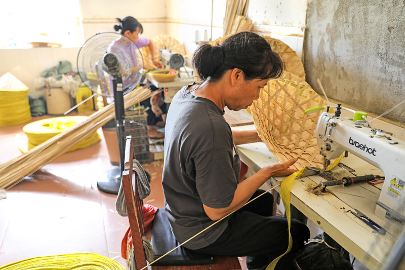 村民在為竹編帽半成品加工