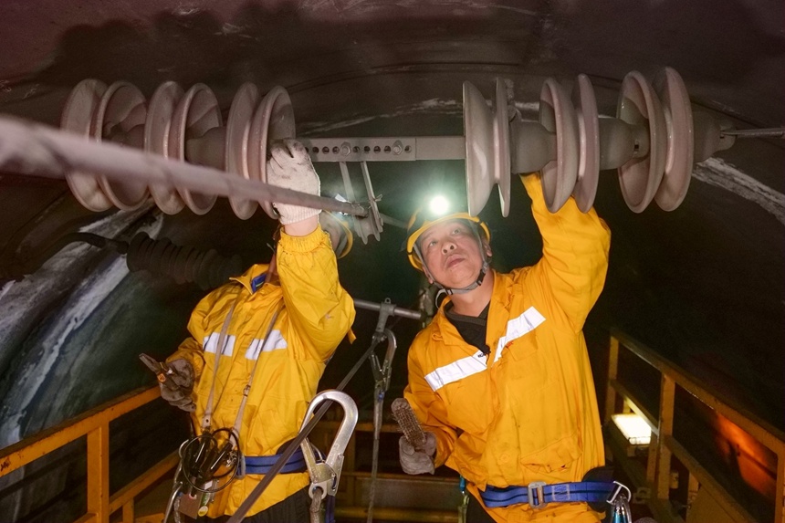作業(yè)人員正在檢調(diào)隧道內(nèi)的接觸網(wǎng)絕緣子。
