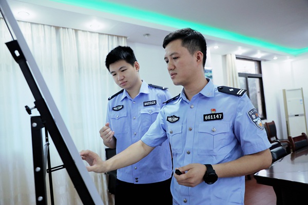 黃路(右)與同事討論案情