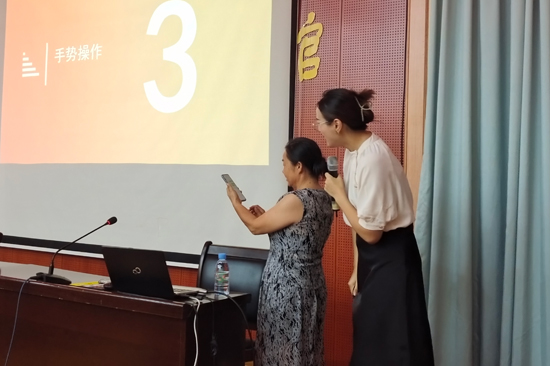 志愿者在向老年人講解智能手機(jī)使用方法。橫州市團(tuán)委供圖