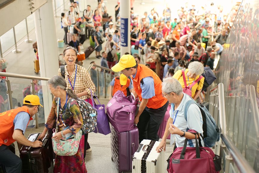 鐵路志愿者引導(dǎo)旅客進(jìn)站乘車。何毅攝