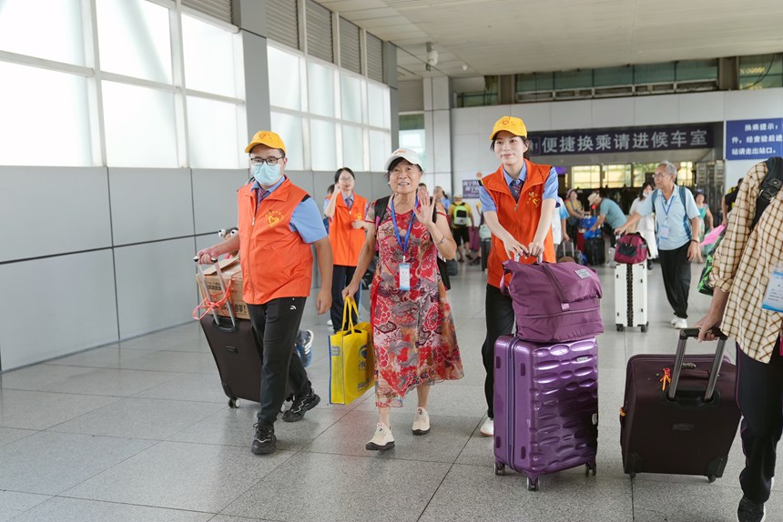 鐵路志愿者引導(dǎo)旅客進(jìn)站乘車(chē)。蘭軻艨攝