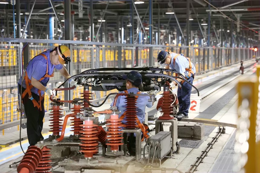 圖為地勤機械師在檢查車頂高壓設(shè)備。廖炳達攝