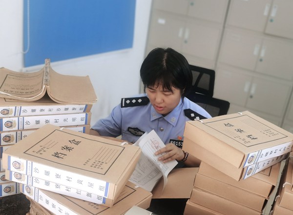 戶(hù)籍民警在翻找紙質(zhì)檔案為群眾尋找已故親人照片