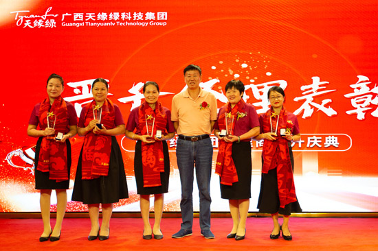 黃建國與晉升經(jīng)理的代理商合影。張興勇攝