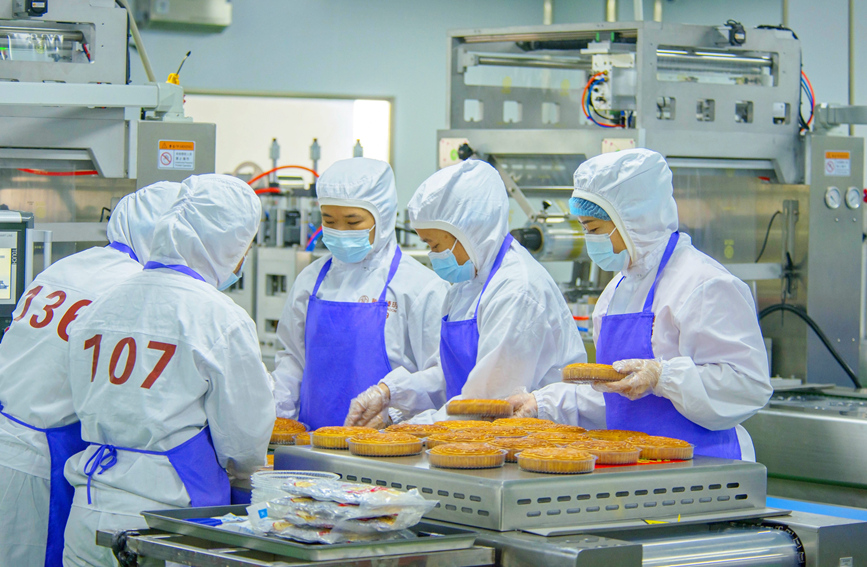 工作人員正在生產(chǎn)線上生產(chǎn)月餅。徐紹榮攝