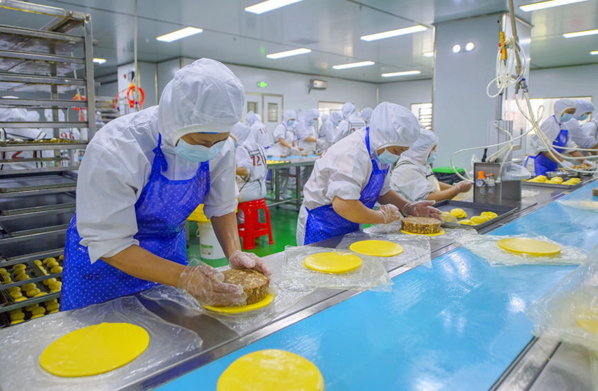 工作人員正在生產(chǎn)線上生產(chǎn)月餅。徐紹榮攝