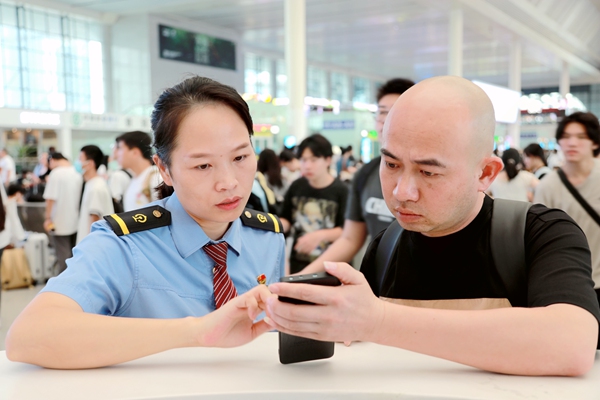 南寧東站工作人員幫助旅客查看行程信息。于莉攝