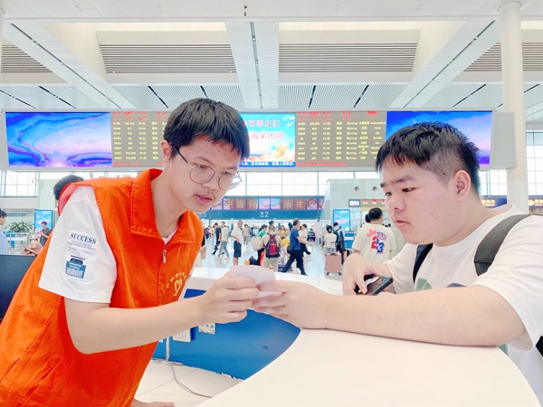 南寧東站志愿者解答旅客問詢。于莉攝