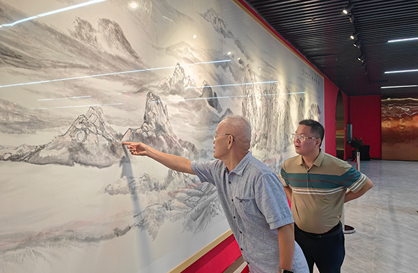 黃云峰（右）與嘉賓進(jìn)行畫(huà)作探討。主辦方供圖