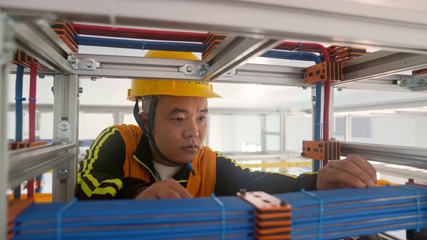 施工人員檢查機(jī)房上走線電纜布放。安智翔攝