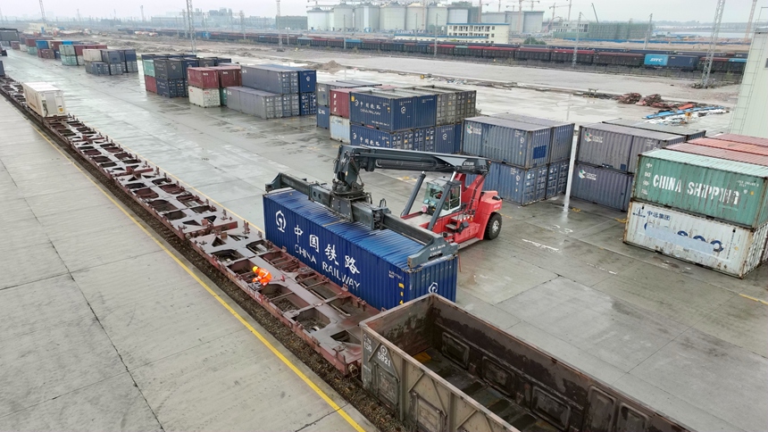 正面吊作業(yè)車正在吊裝集裝箱至鐵路貨車。秦瀚新攝