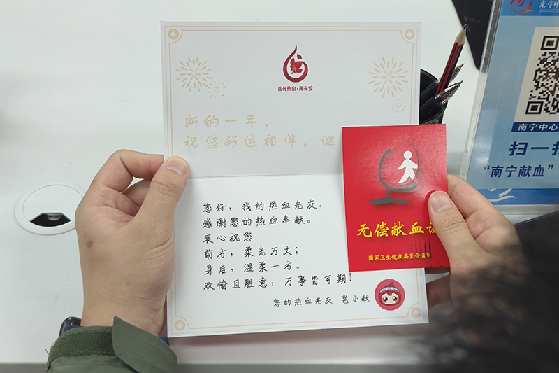 覃天虹獻(xiàn)血后領(lǐng)取無(wú)償獻(xiàn)血證。孫赟飛攝